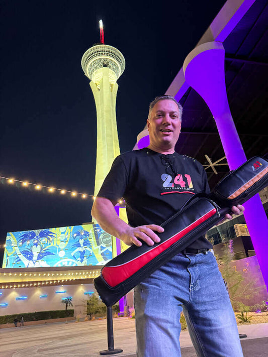 Guy holding 241 cue case in front of Strat in Vegas