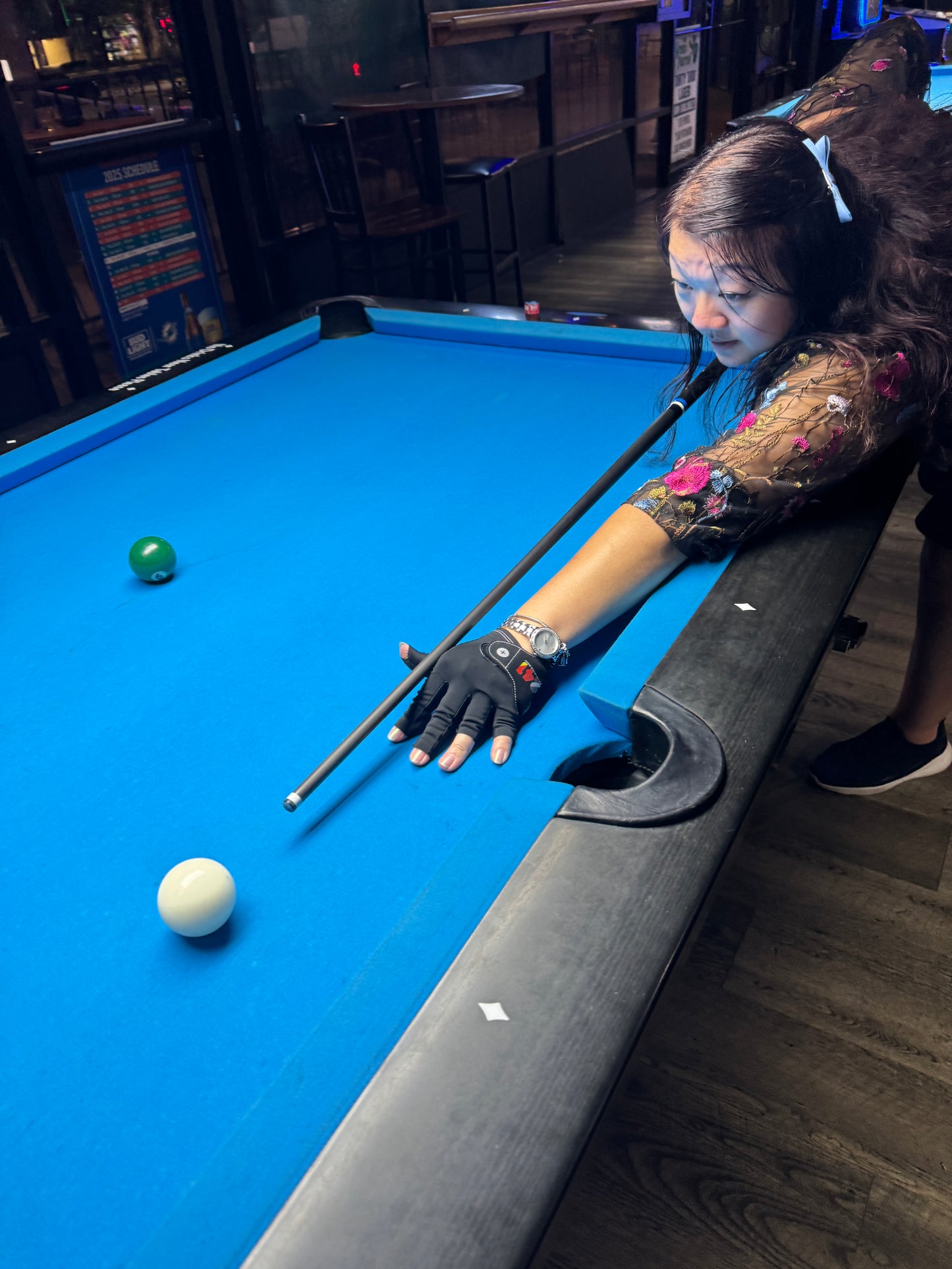 Girl taking pool shot with carbon fiber Kamui cue tipped Beatstix